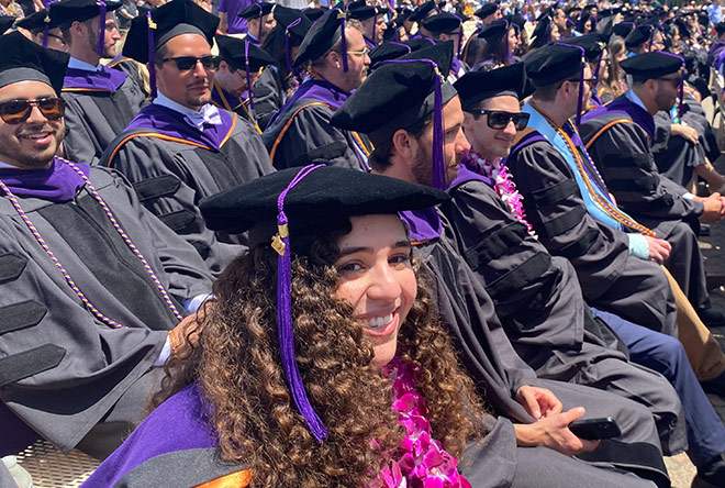 Students sitting and smiling during commencement