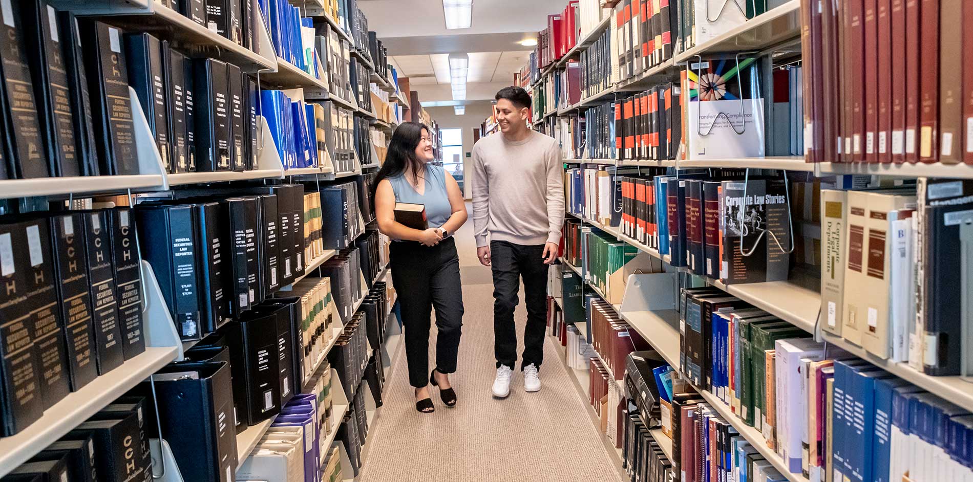 Students walking in library stacks