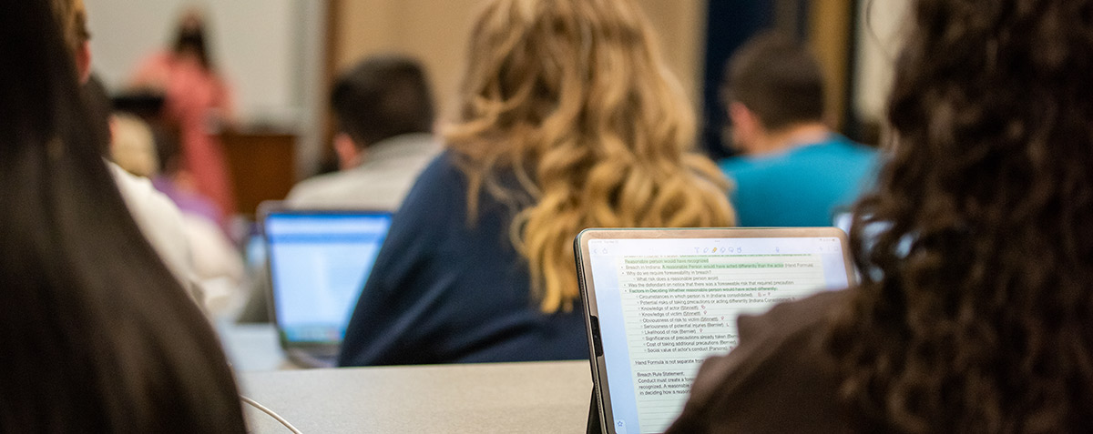 close up student with computer in classroom