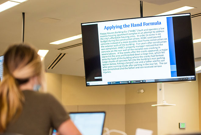 Student on computer classroom looking at large monitors