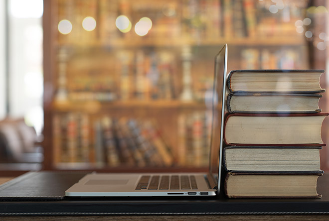 computer and books on table in a library