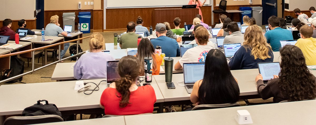 Students taking notes on laptop during a class lecture