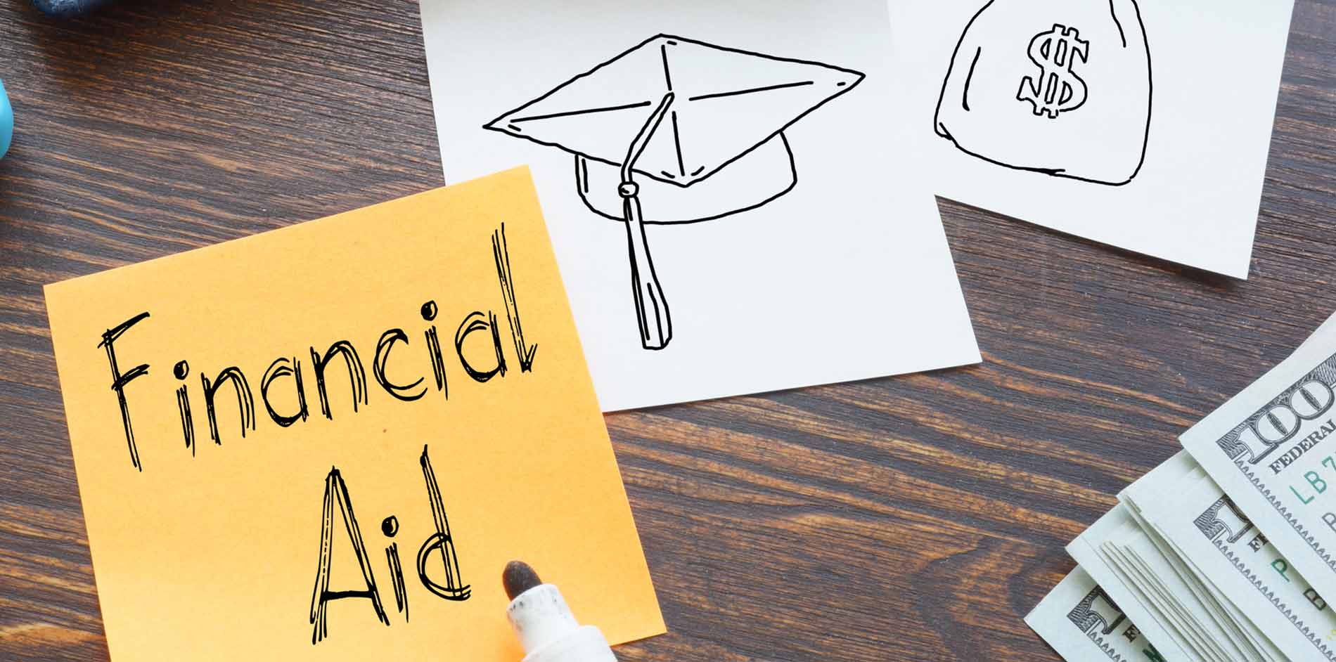 Financial Aid written on post it with two post its with money bag and graduation cap drawing