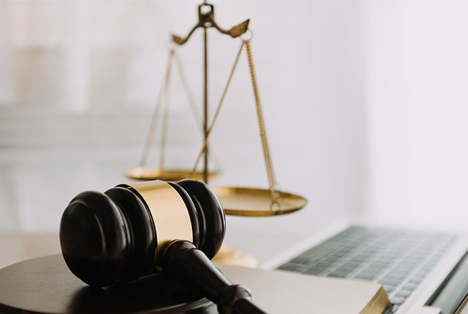 Gavel with computer and justice scales on desk