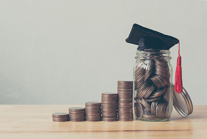 Graduation cap atop a jar of coins