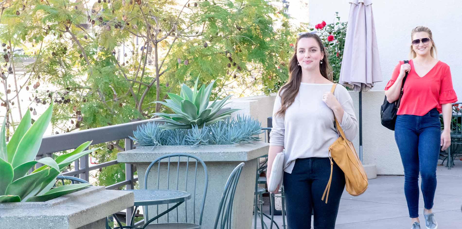 Two female students walking on the side courtyard at California Western School of Law