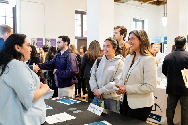 Students networking with an Alumnus