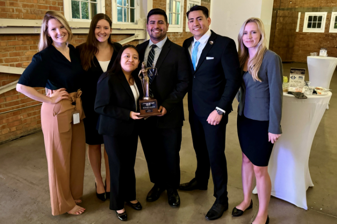 Six students pose with a trophy