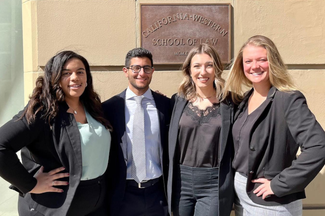 Four students pose in front of sign that reads California Western School of Law