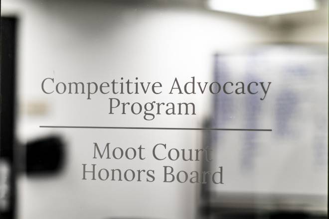 "Competitive Advocacy Program | Moot Court Honors Board" written on a glass door