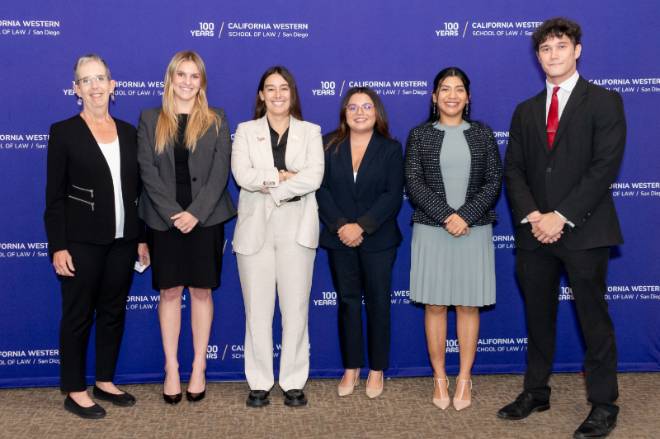 Five students and a faculty member line up in front of a CWSL banner for a group photo