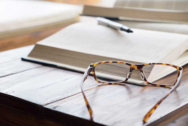 book and market with glasses on table