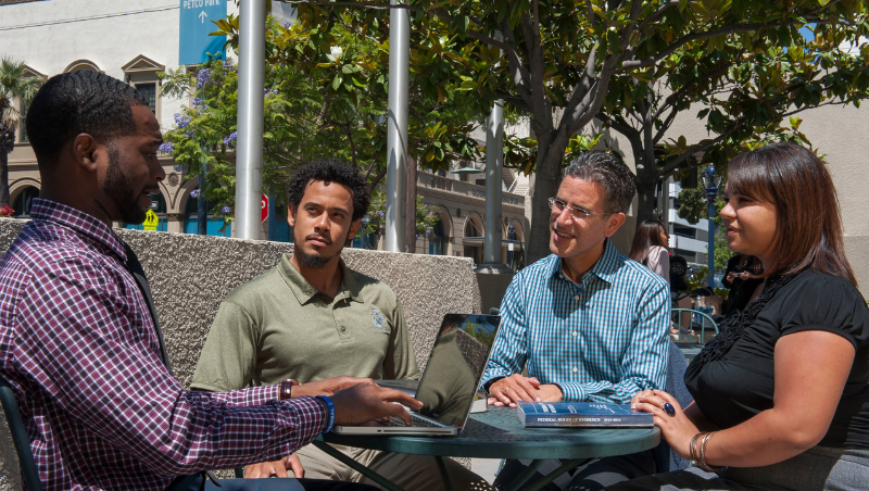 Professor William Aceves meets with students in the CWSL courtyard.