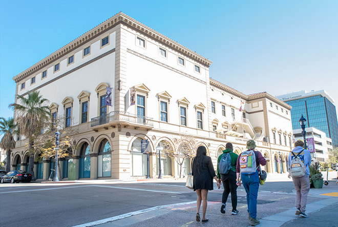 corner of classroom building with students walking