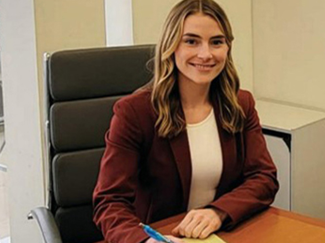 Greer Houston at a desk with legal pad during her clinical externship