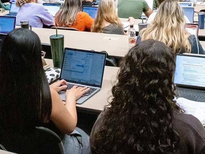 Students on laptop in lecture hall 