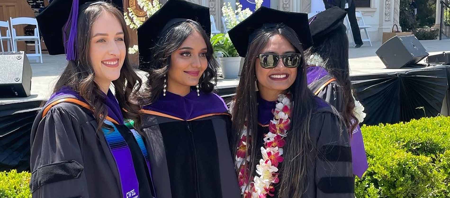 Three graduates talking a picture after the California Western School of Law commencement