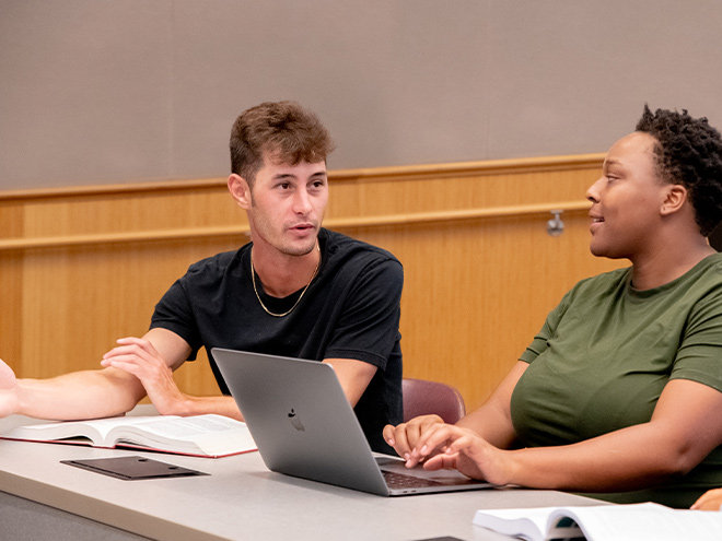 Two students talking in class auditorium