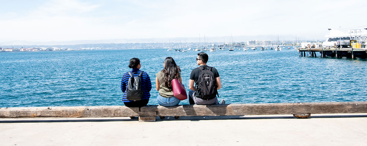 students sitting near the water at embarcadero